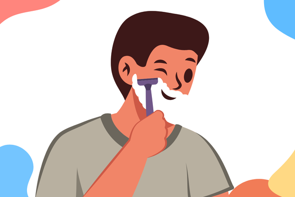 Bearded man grooming his beard in the mirror using beard oil and a wooden comb